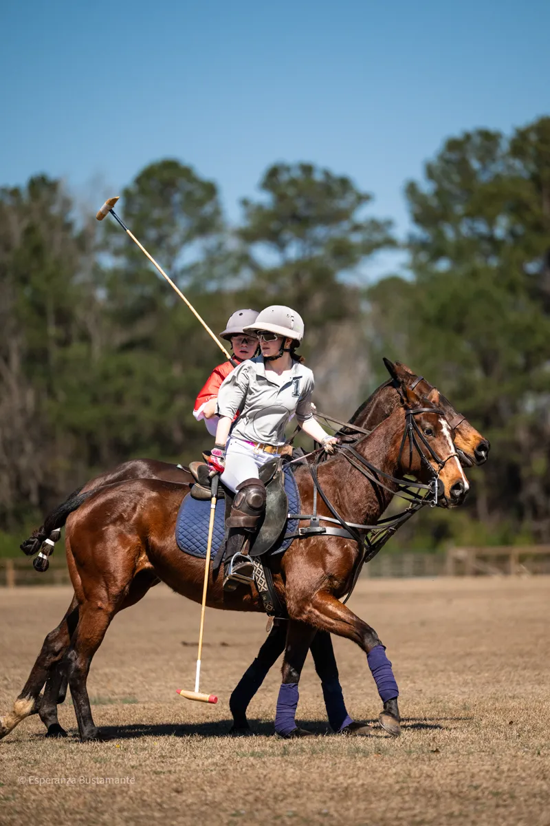 Two polo riders competing for position on the field